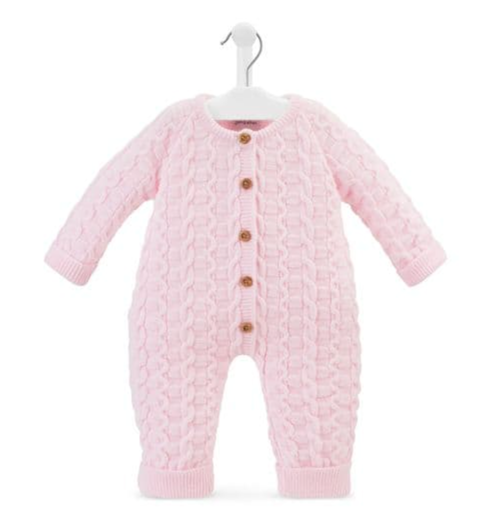 Dandelion basket weave knitted baby onesie in soft blush pink on a white hanger against a white background; full front view of a footless all-in-one with long sleeves and long legs; three-dimensional knit combining interlocking basket weave oval loop panels on the body and sleeves with twisted rope cable columns running vertically down the centre front and sides; five round warm brown buttons down the centre front placket; round neckline with narrow ribbed neckband; ribbed cuffs at sleeve ends and leg ends