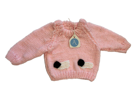 pink knitted jumper with 2 black and white sheep on a white background