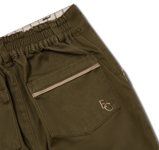 Close-up of olive green pants with a pocket and brand logo. BOYS ELASTICATED WAIST CHINO TROUSERS - KHAKI WITH STONE TRIM | ELEANOR CHARLES