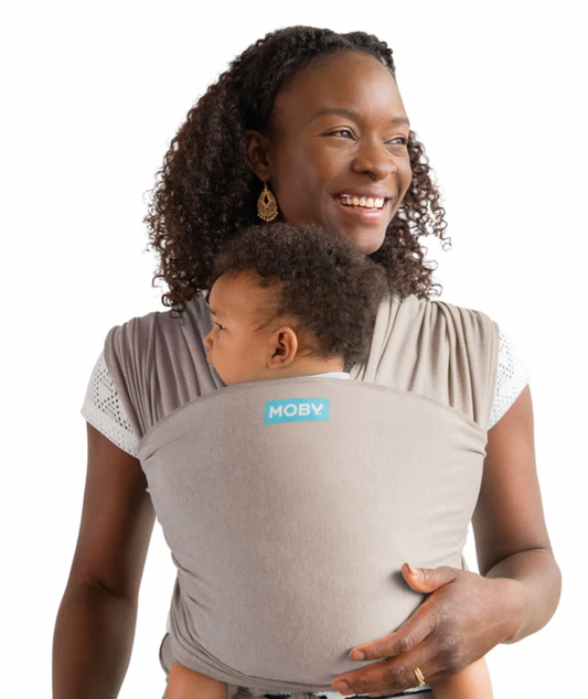Woman carrying a child in a Moby baby carrier. ELEMENTS SOFT & ADJUSTABLE FEATHER KNIT BABY WRAP CARRIER - 2 COLOURS | MOBY