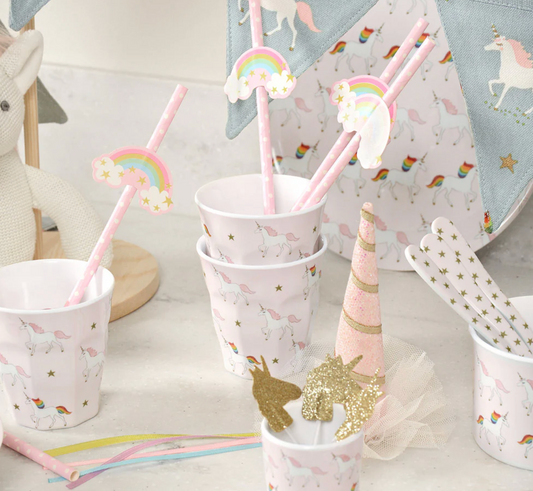 Unicorn-themed party supplies including cups, straws, and a cone on a light surface. MELAMINE BEAKER - UNICORN | SOPHIE ALLPORT