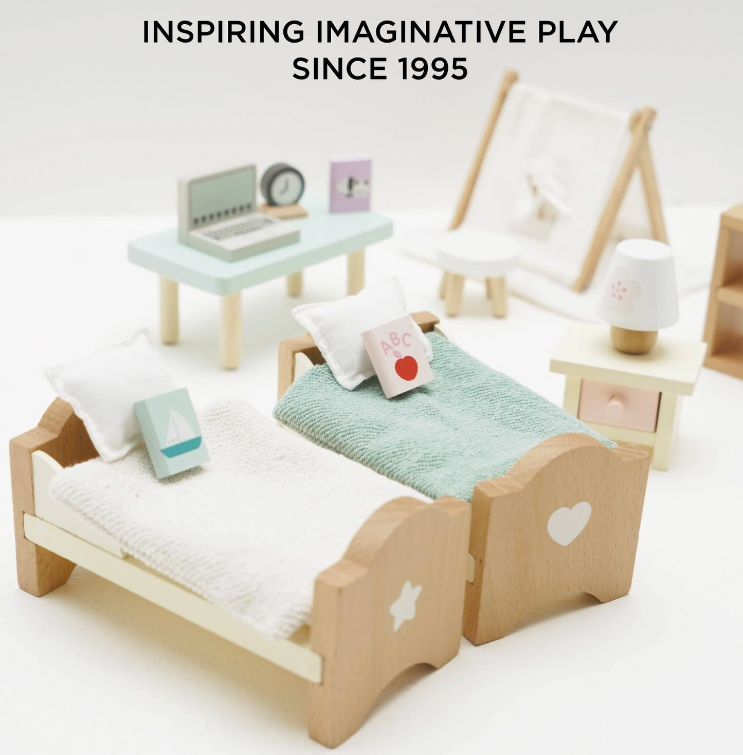 Le Toy Van children's bedroom dolls house furniture set — lifestyle image of a child playing with the wooden bedroom furniture set, arranging the miniature pieces