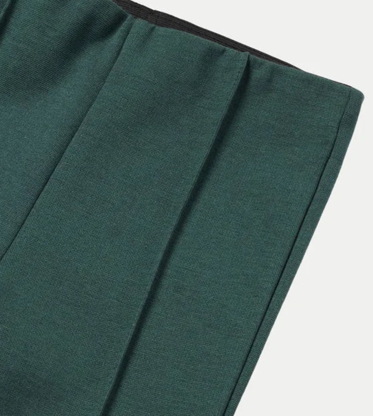 Close-up detail of Mayoral emerald green flared trousers showing the stretch fabric texture and elasticated waistband