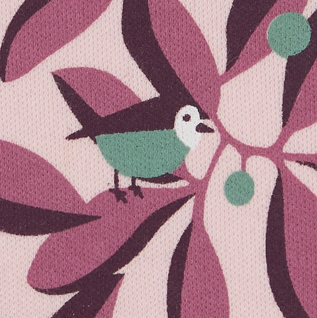 Close-up — individual bird in sharp focus (plum wing, teal body, white cheek, dark beak); teal berry cluster; leaf layers; jersey fabric texture.