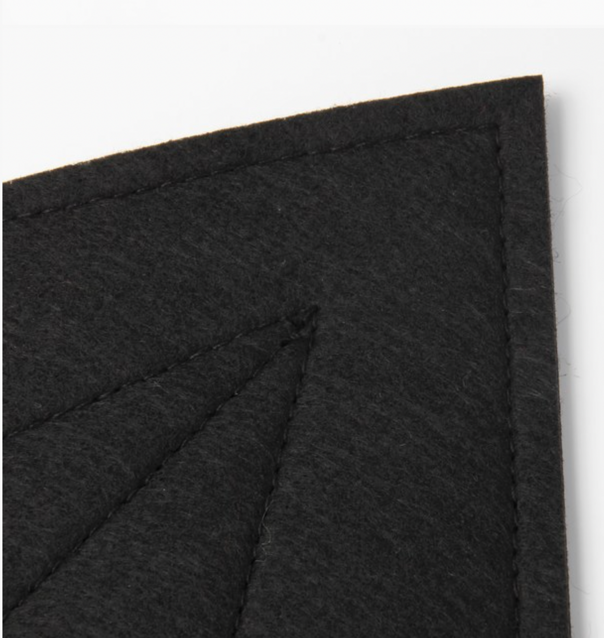 Close-up of Molly & Rose black polyester bat-wing fabric showing the dark woven texture and stitched panel detailing⠋