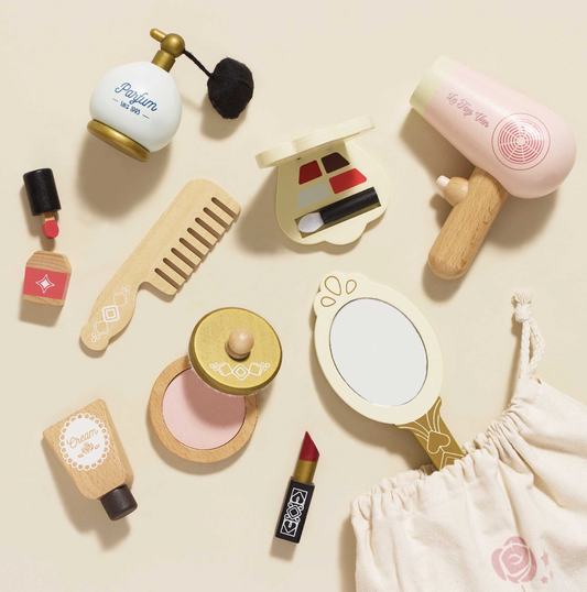 Collection of miniature cosmetic items including a perfume bottle, comb, mirror, and lipstick on a beige background. VANITY STAR BEAUTY KIT & WOODEN ACCESSORIES | LE TOY VAN