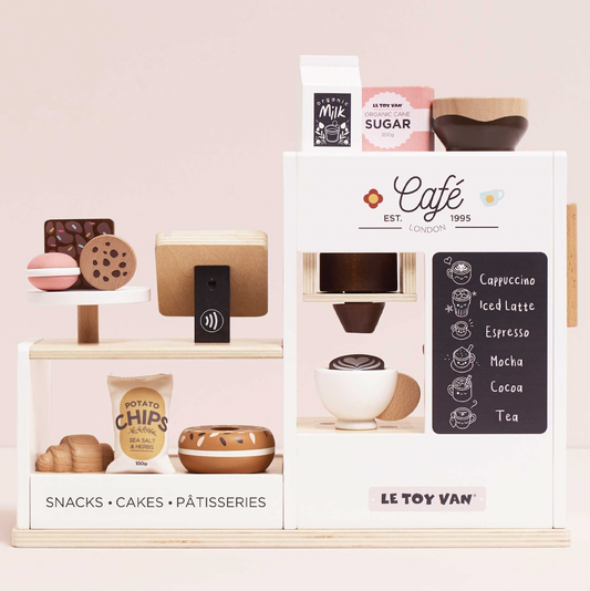 Playset with coffee machine, snacks, and cakes on a pink background, featuring Le Toy Van branding. WOODEN BARISTA CAFE SHOP | LE TOY VAN