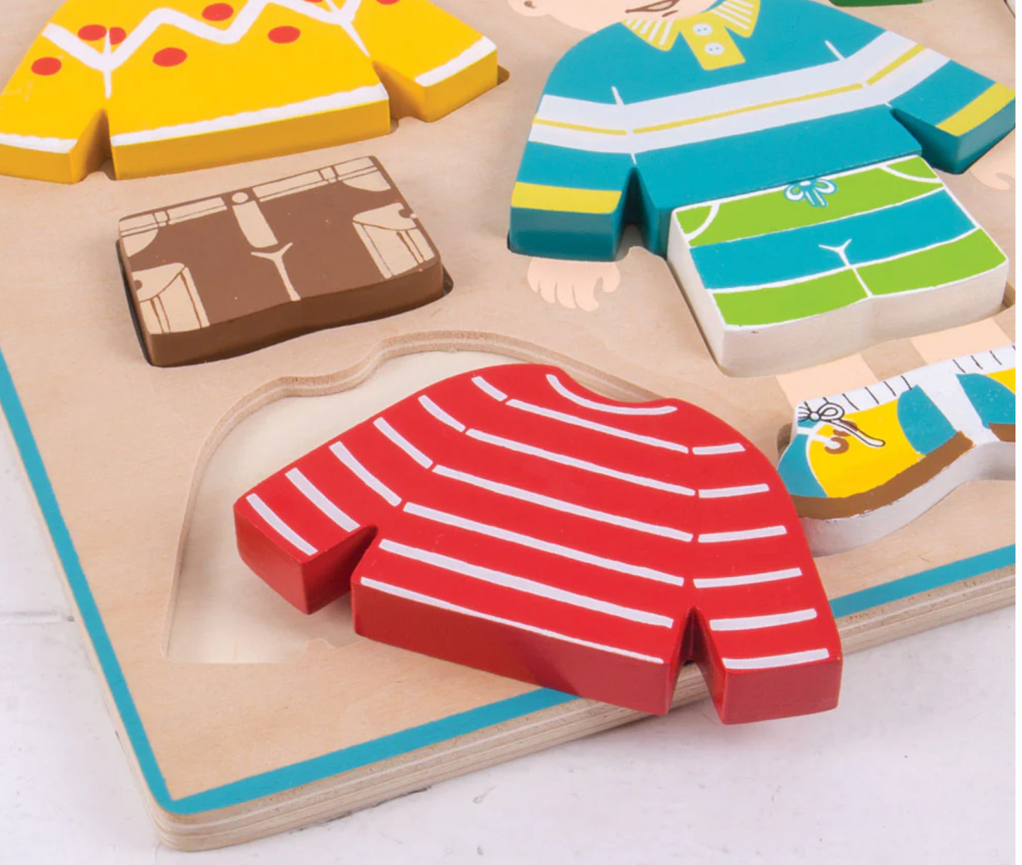 Wooden puzzle with colorful clothing pieces on a wooden board WOODEN DRESS UP PUZZLE | BIGJIGS