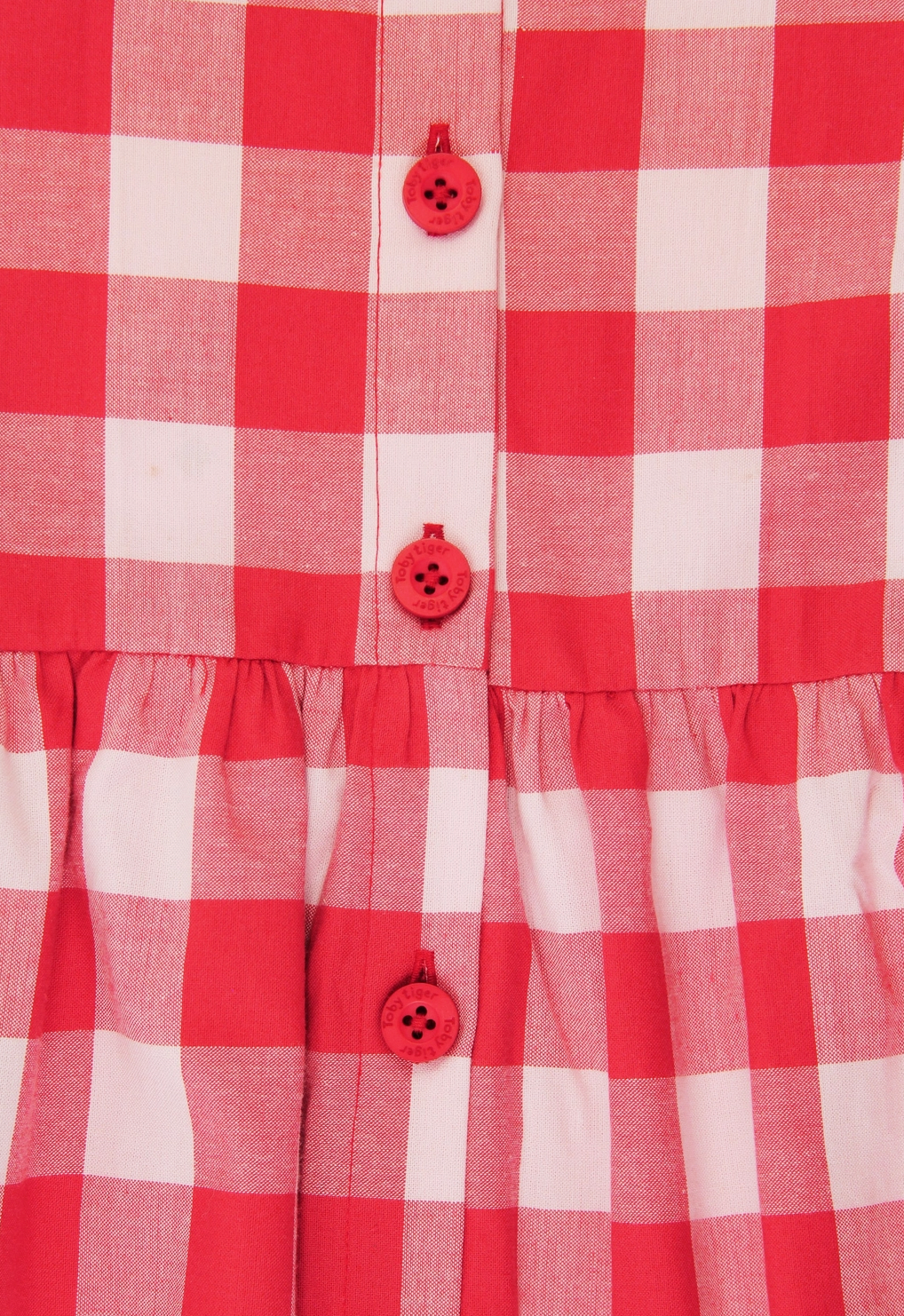 Close-up view of the premium organic woven cotton gingham check fabric and gathered waistline.