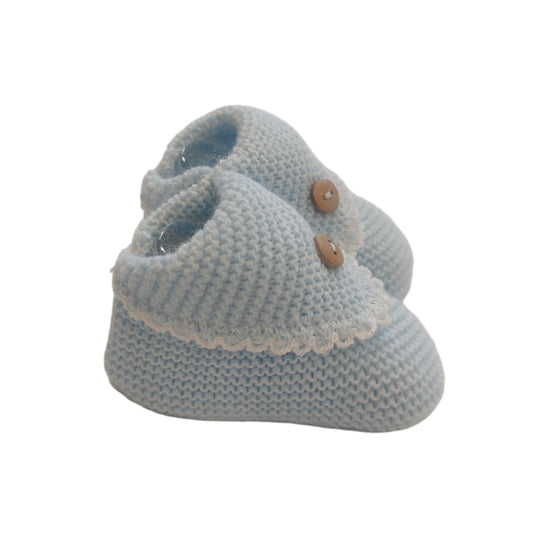 Blue crochet-knit baby booties shown from a side angle on a white background; the rounded toe, ribbed ankle cuff, textured knit body, scalloped flap and button detail are visible
