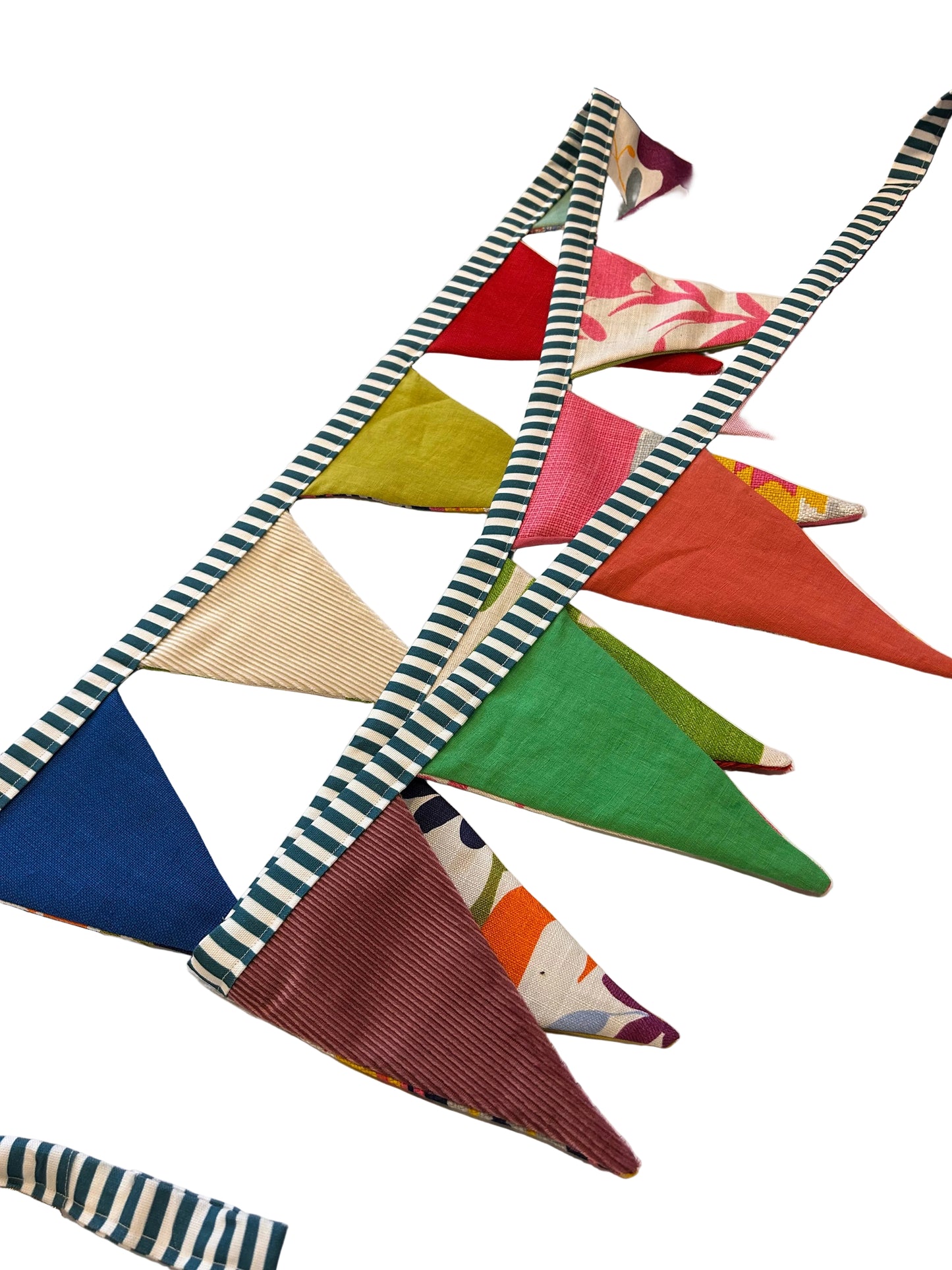Colorful fabric triangles arranged in a pattern on a shelf with craft supplies in the background.