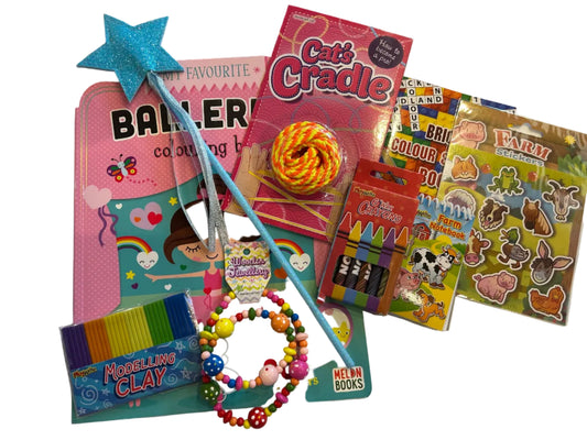 A children's toy and craft bundle arranged on a white fabric surface, including a pink coloring book, a blue star wand, a 'Cat's Cradle' toy, crayons, bead bracelets, stickers, and modeling clay.