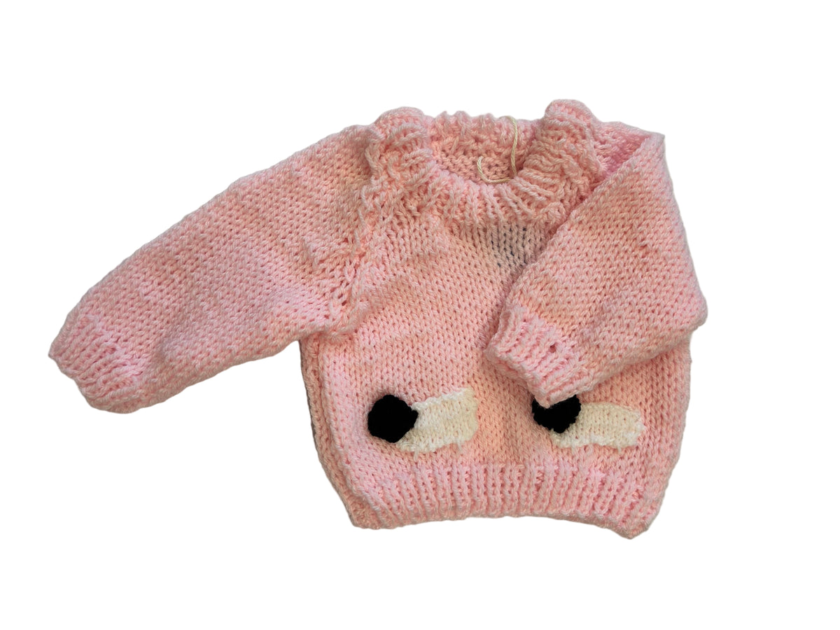 Angled front on white — loopy bouclé ruffle collar very prominent; two intarsia sheep with black pompom heads; no tag.