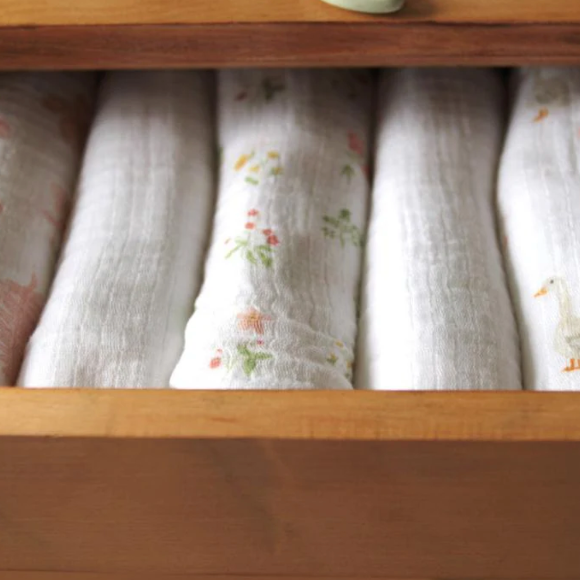 Folded fabric swaddles in a wooden drawer ADEN + ANAIS 5 PACK BABY MUSLIN SQUARES - COUNTRY FLORAL