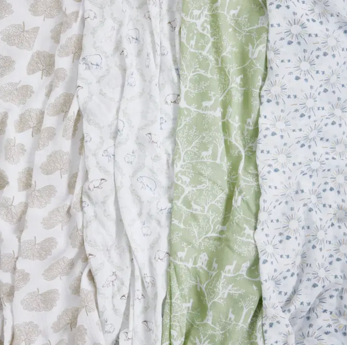 Three pieces of fabric with different patterns and colors arranged side by side. ADEN + ANAIS COTTON BABY SWADDLE 4 PACK - HARMONY