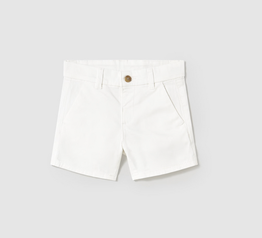 Mayoral Baby Basic Summer White Chino Shorts — front ghost flat-lay on light grey background; white/off-white smooth cotton-elastane chino twill shorts; structured waistband with two belt loops visible at the front; single round bronze/antique brass button at the centre front waistband; two slanted/angled side welt pockets at the front; clean tailored silhouette with a mid-thigh length; light grey background; demonstrates the full front silhouette, bronze button and slanted front pocket detail