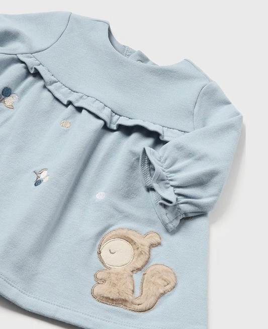 Mayoral baby girls polar blue fleece squirrel dress — close-up detail showing the gathered yoke with double ruffle trim, elasticated ruffle cuff on the long sleeve, scattered embroidered acorn and leaf details in navy and gold thread, and the large 3D sandy bouclé squirrel appliqué with embroidered closed eyes and fluffy tail on the polar blue fleece skirt