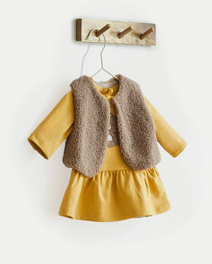 Mayoral  girls Yellow dress with brown fur vest outfit set hanging on a wooden hook. BABY GIRL TEDDY DRESS, GILET & HEADBAND SET - SAFFRON YELLOW | MAYORAL