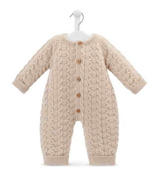 Dandelion basket weave knitted baby onesie in warm oatmeal taupe on a white hanger against a white background; full front view of a footless all-in-one with long sleeves and long legs; three-dimensional knit combining interlocking basket weave oval loop panels on the body and sleeves with twisted rope cable columns running vertically down the centre front and sides; five round gold-toned buttons down the centre front placket; round neckline with narrow ribbed neckband; ribbed cuffs at sleeve ends andbuttons