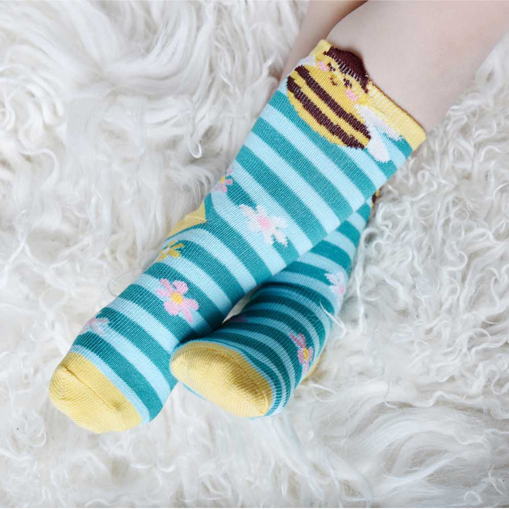 Colorful striped socks with floral designs on a fluffy white surface. CHILDREN'S BEE & BLUE STRIPE SOCKS - 3 SIZES | POWELL CRAFT