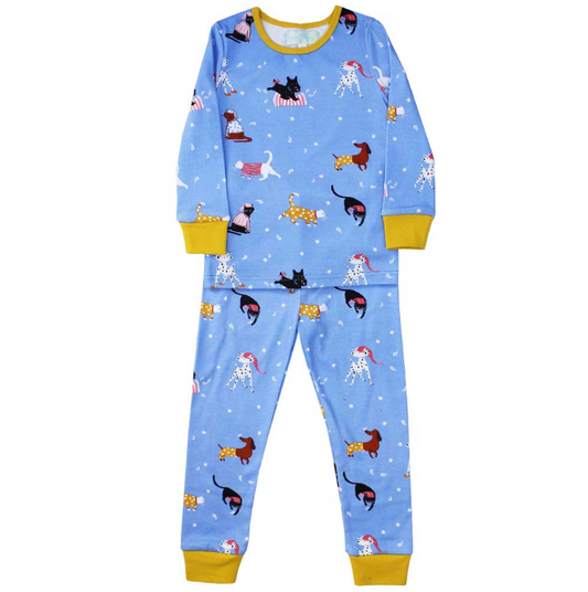  Powell Craft children's cat and dog print cotton jersey pyjama set laid flat on a white background; slightly larger size variant showing the same cornflower blue all-over print with dogs and cats in pyjamas and nightcaps; white stars and crescent moon scatter on the blue ground; white Dalmatian in red and pink striped nightcap, brown dachshund in mustard polka-dot coat, black Scottie dog on a red and white striped cushion, black cat at play, white cat in pink striped cape, ginger tabby in mustard spotted j