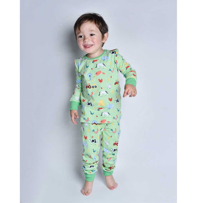 Child wearing green pajamas with farm animal prints. CHILDREN'S COSY FARMYARD COTTON PYJAMAS - 3 SIZES | POWELL CRAFT