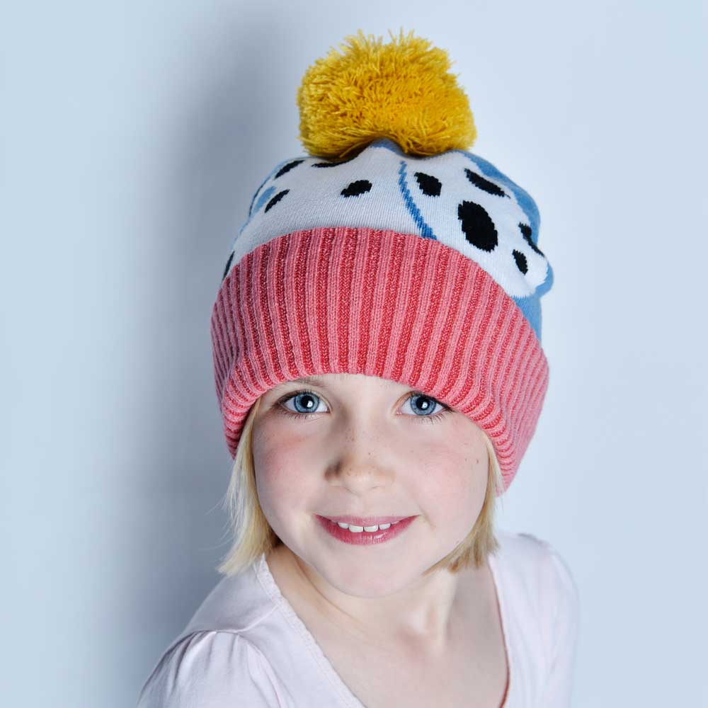 Child wearing a colorful knit hat with a yellow pom-pom. CHILDREN'S DOG KNITTED HAT WITH POM-POM | POWELL CRAFT