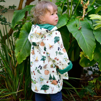 Child wearing a patterned jacket standing among green plants. CHILDREN'S GREAT OUTDOORS RAINCOAT - 3 SIZES | POWELL CRAFT