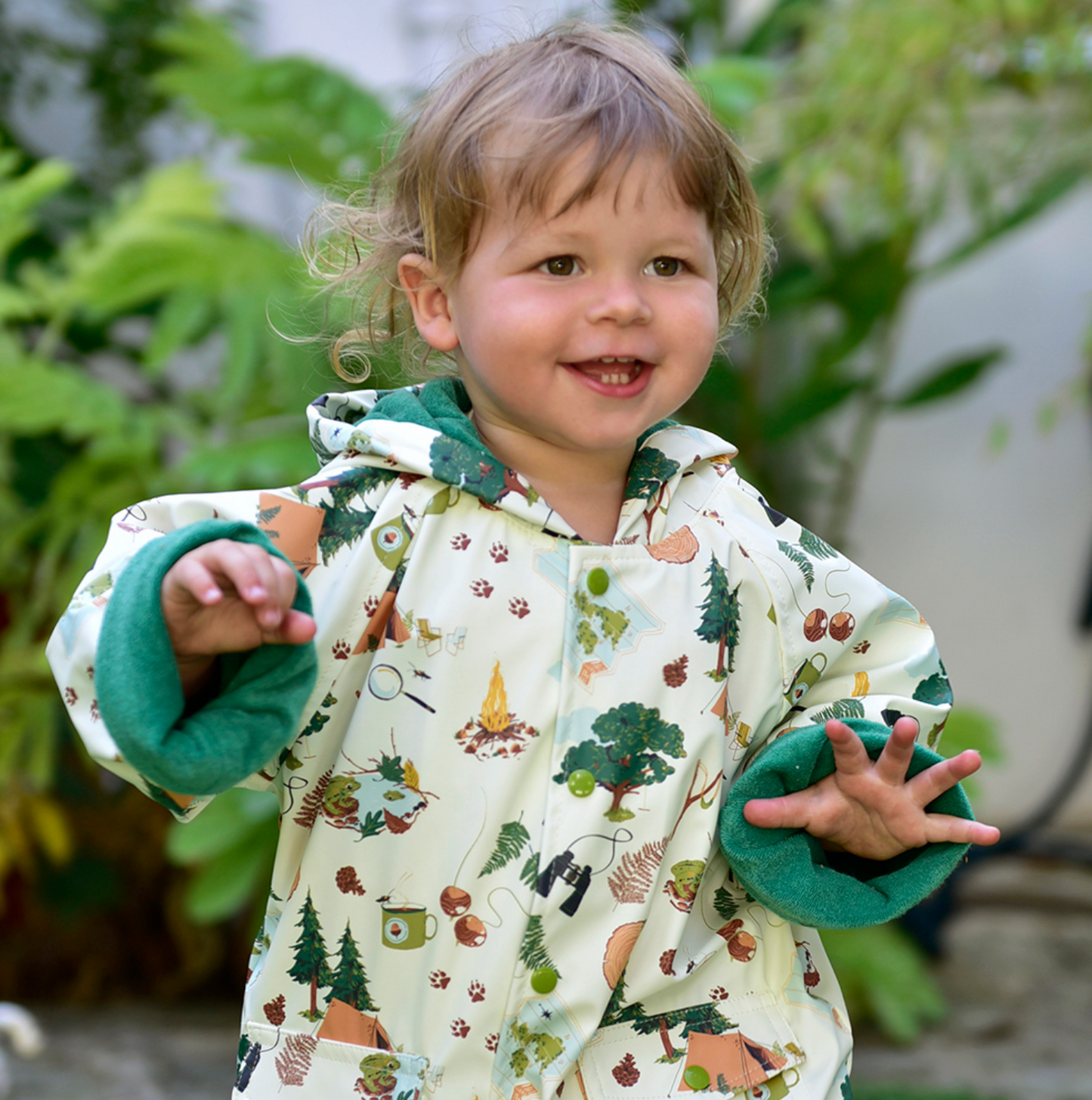 Child wearing a patterned outfit with nature-themed design outdoors. CHILDREN'S GREAT OUTDOORS RAINCOAT - 3 SIZES | POWELL CRAFT