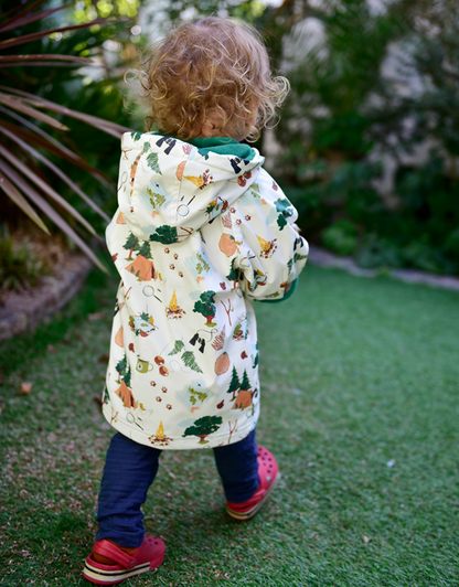 Child wearing a patterned coat walking outdoors on grass. CHILDREN'S GREAT OUTDOORS RAINCOAT - 3 SIZES | POWELL CRAFT