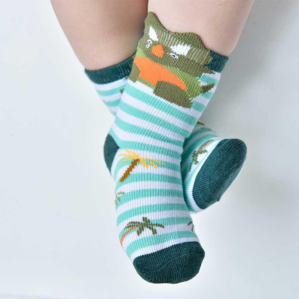 A pair of children's socks with green and white stripes and dinosaur motifs, including a triceratops design at the top. CHILDREN'S GREEN DINOSAUR STRIPE SOCKS - 3 SIZES | POWELL CRAFT