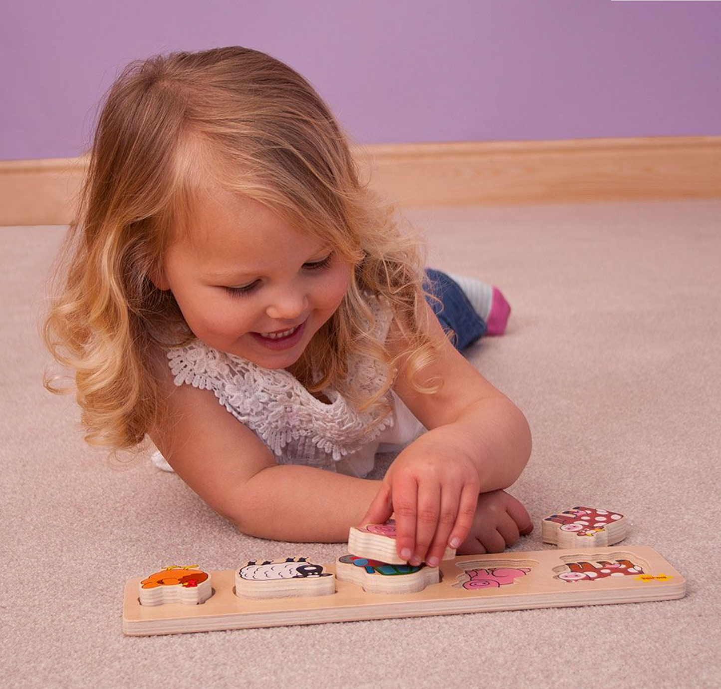 A child playing with a wooden pet puzzle with chunky pieces on a floor. CHUNKY LIFT & MATCH PUZZLE - PETS | BIGJIGS