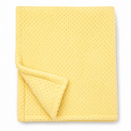 Snuggle Baby lemon yellow cosy baby wrap — folded soft fleece wrap with waffle honeycomb texture throughout in a soft lemon yellow, showing corner turned back to reveal the texture detail, on white background
