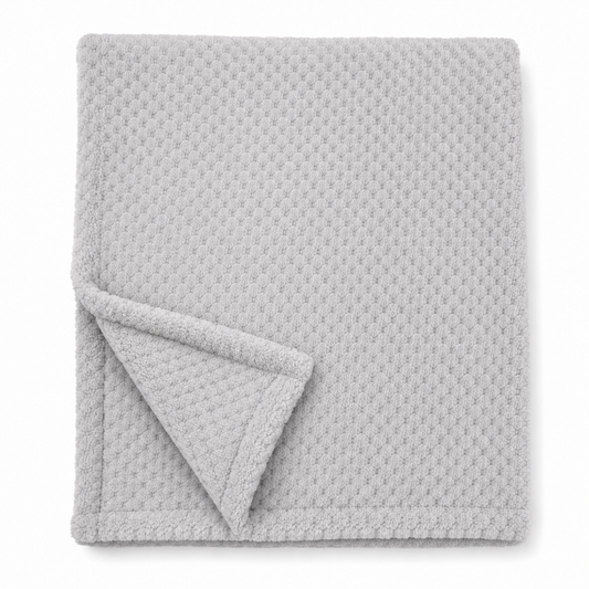 Snuggle Baby neutral plain grey cosy baby wrap — folded soft fleece wrap with waffle honeycomb texture throughout in a soft light grey, showing corner turned back to reveal the texture detail, on white background