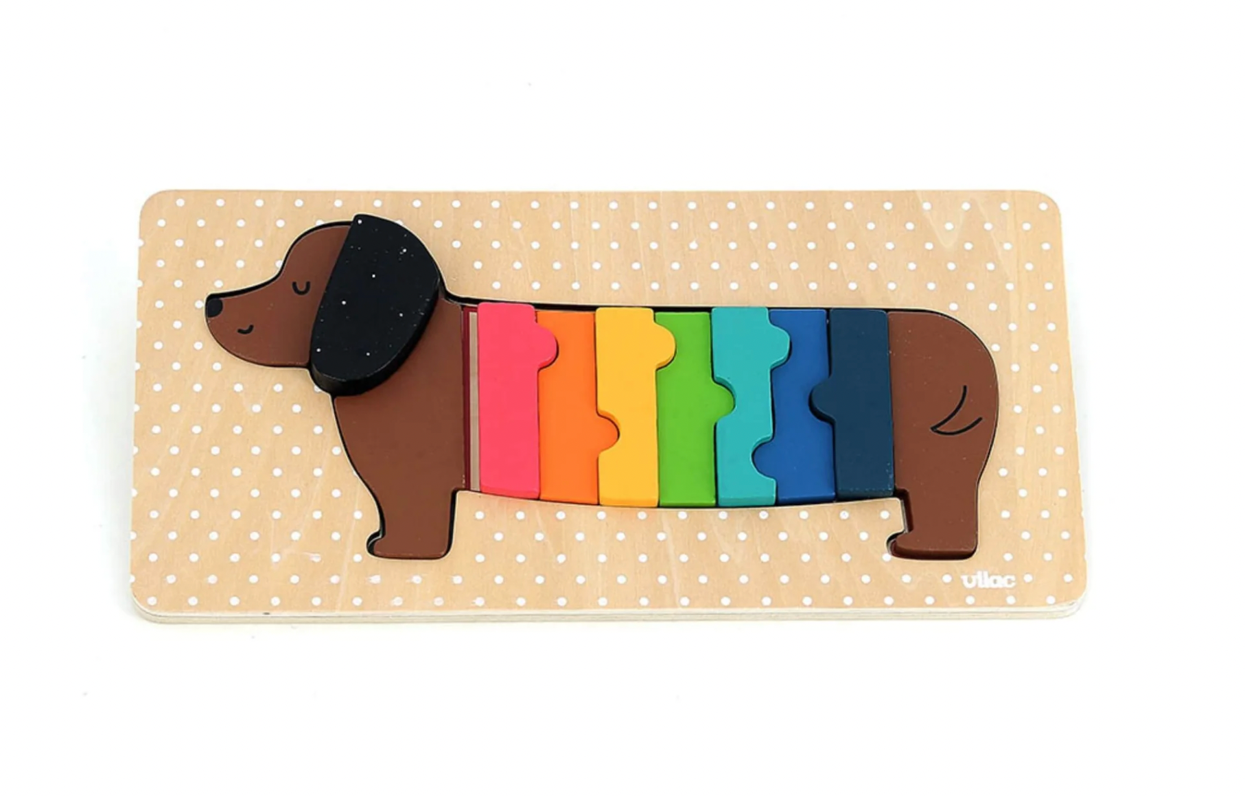Colorful dachshund-shaped puzzle on a beige background with white polka dots