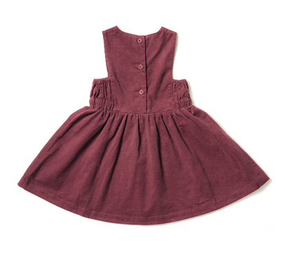 Maroon dress with buttons on a white background. GIRLS BURGUNDY CORD PINAFORE DRESS | ELEANOR CHARLES