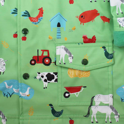 Green children's clothing with farm animal patterns on a close-up of the pocket. KID'S FARMYARD LINED RAINCOAT - 4 SIZES | POWELL CRAFT