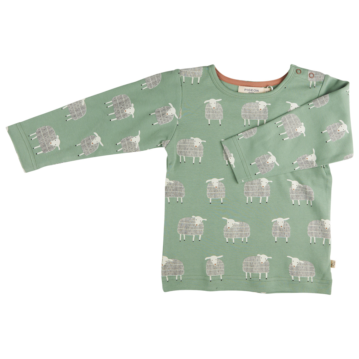 Pigeon Organics Organic Cotton Long-Sleeve T-Shirt in Green Basil Sheep shown flat on a white background; sage basil-green fabric with an all-over repeating folk-art illustrated sheep print — each motif has a large rounded body filled with a crosshatch grid texture in off-white and pale grey, four short off-white legs, and a small white head turned slightly to one side with a simple dot eye and small dark dot markings at the hoof tips; round crew neckline with a contrasting warm terracotta-peach background.
