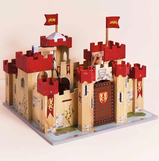 Wooden toy castle with red towers and flags on a beige background LIONHEART WOODEN TOY CASTLE | LE TOY VAN