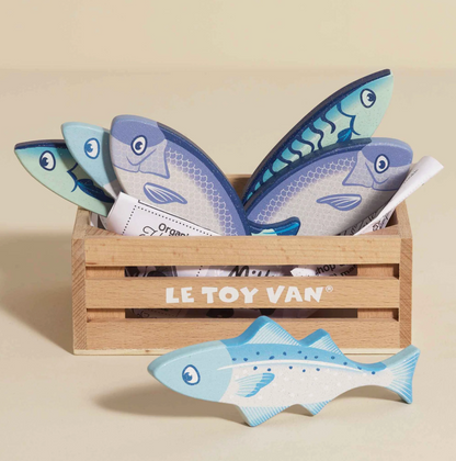Set of toy fish in a wooden crate with 'Le Toy Van' branding on a beige background. MARKET FISH WOODEN TOY CRATE | LE TOY VAN