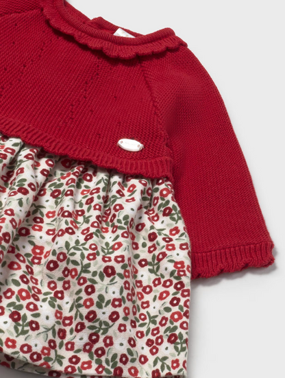 Close-up — knit texture vs woven floral contrast; scalloped neckline edge; silver badge; fabric transition point; pointelle detail. 