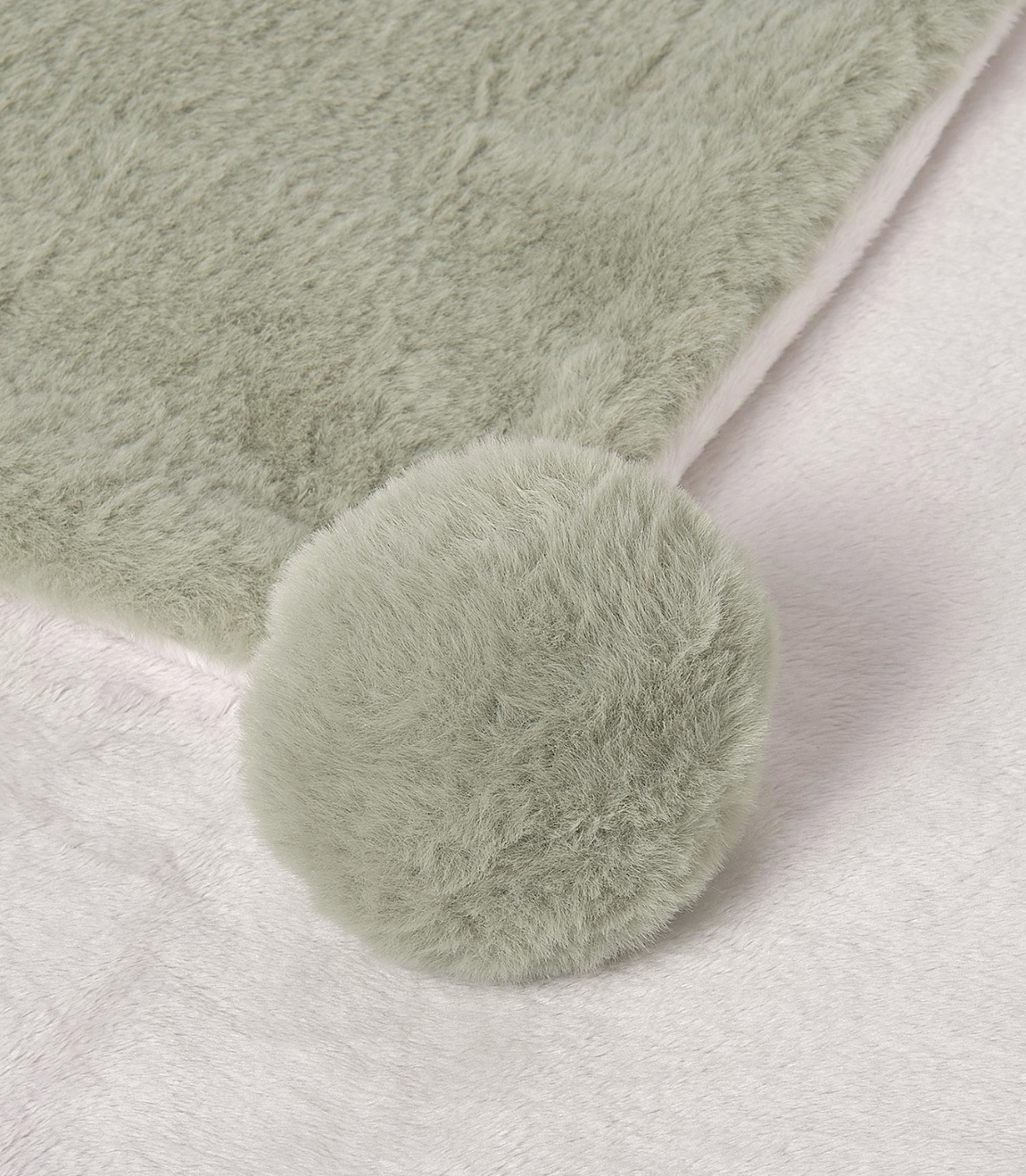Light green fluffy BLANKET with a pom-pom on a white background. MAYORAL FAUX FUR BABY POM POM BLANKET - SAGE