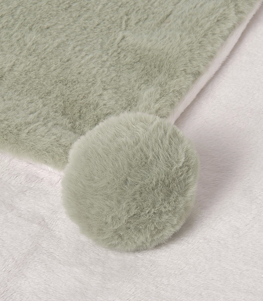 Light green fluffy BLANKET with a pom-pom on a white background. MAYORAL FAUX FUR BABY POM POM BLANKET - SAGE