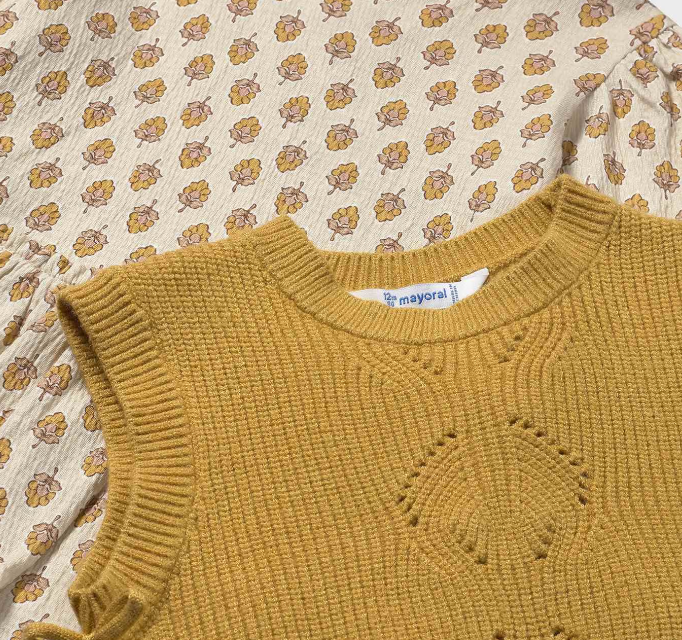 Close-up — floral posy print in detail; seed-stitch knit; diamond eyelet panel; Mayoral label.