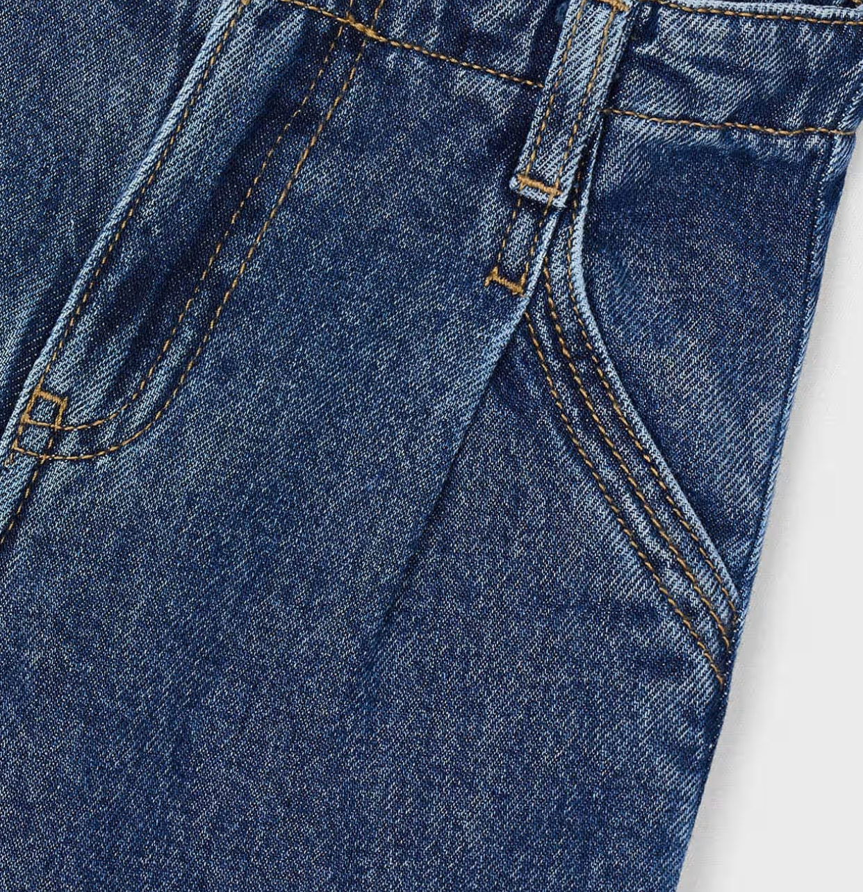 Close-up of blue denim fabric with stitching details on a white background. Pair of GIRLS MAYORAL blue WIDE LEG jeans. GIRLS FLARED DENIM JEANS - DARK WASH | MAYORAL 