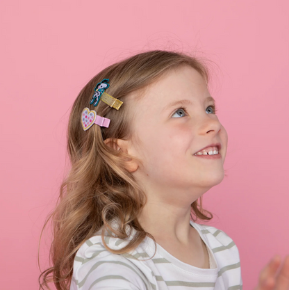 Young girl with colorful hair clips on a pink background RACHEL ELLEN HAIR CLIPS - DOGS