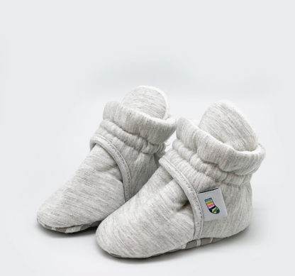 Pair of gray baby booties on a light gray background