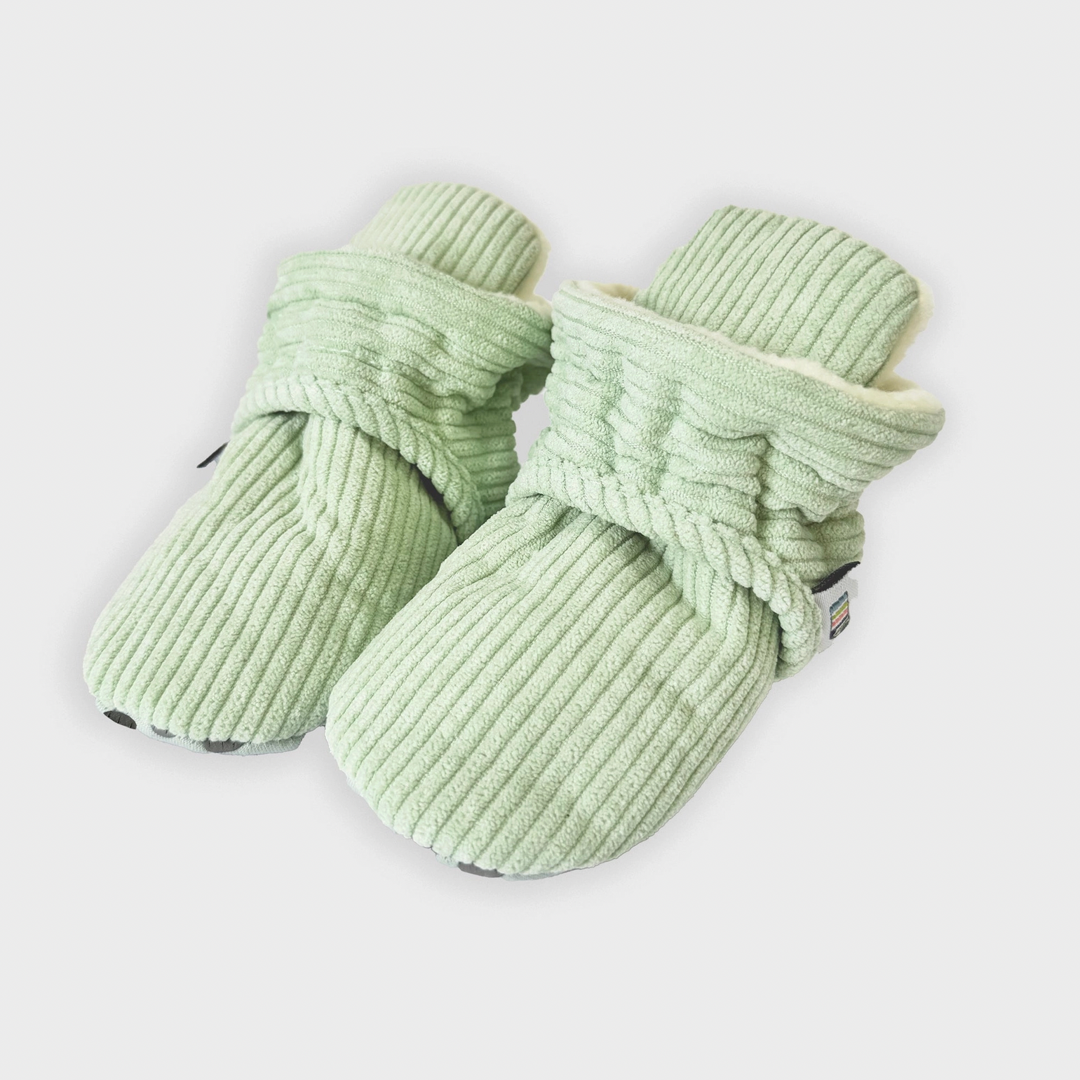Pair of light green knitted dog boots on a white background STAY-ON, NON-SLIP BOOTIE - PISTACHIO CORDUROY | THE LITTLE SOCK CO.