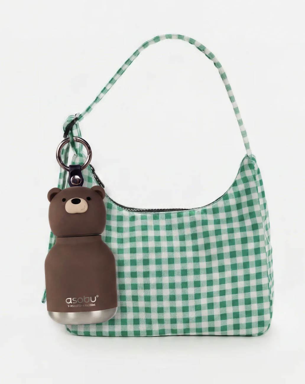 Green and white gingham check shoulder bag with a brown bear-shaped bottle charm attached via a key ring, shown on a plain white background.