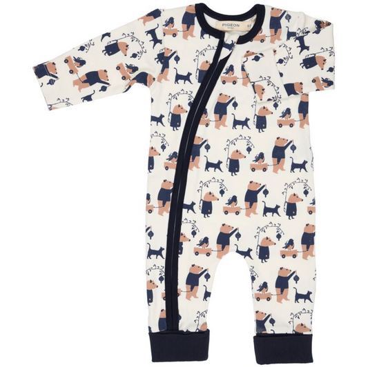 A baby long-sleeve footless romper with a white background and an all-over print of teddy bears and dogs in navy blue and tan. It features a dark navy blue snap closure down the front, a matching navy blue collar, and navy blue cuffs.